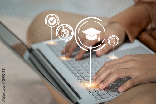 A woman is typing on a laptop with a graduation cap on the screen photo