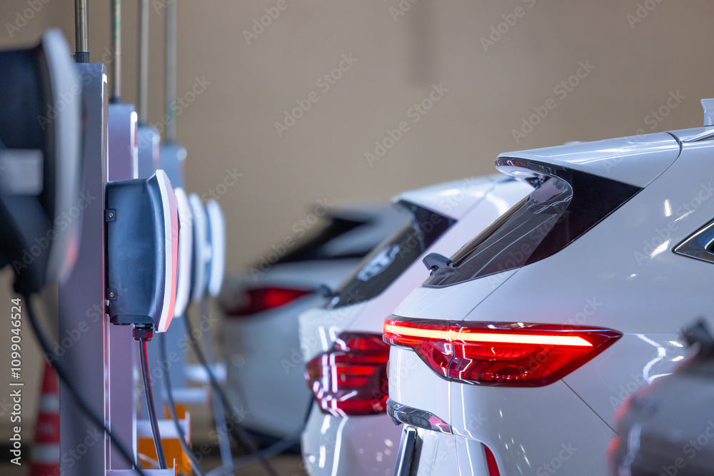 EV charger and electric car, Electric car charger station for charge ev battery, Plug for vehicle with electric engine, EV charger clean energy, Charging point at car parking lot department store.
