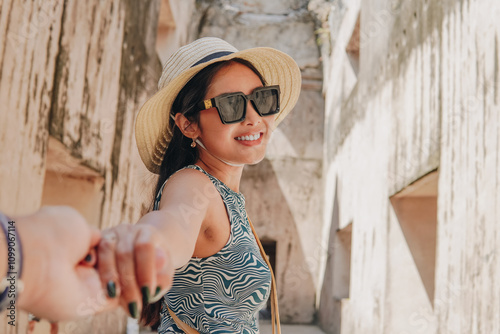 Happy young Asian woman holding hands while enjoying travel in Tamansari Yogyakarta. photo