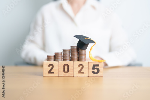 Happy New Year 2025 with Coins stack growing up and graduation hat. Money saving for Education, Scholarship, Student loan and debt and study future plan concept photo