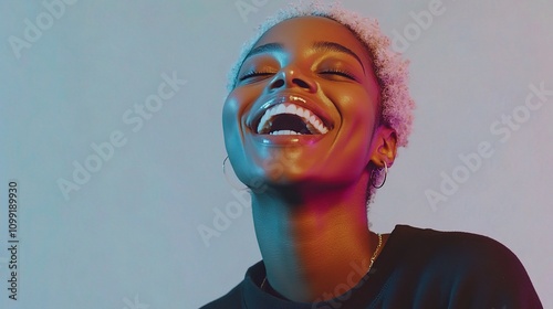 Joyful Black Woman Laughing Heartily in Studio with Colorful Lighting photo