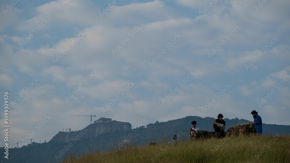 Obraz premium View of three friends making a call on a mountain peak under a clear sky