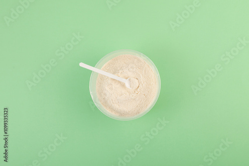 Xanthan Gum Powder with measuring spoon in plastic dish, top view. Food additive E415. Texture improver. Stabiliser and Thickener. Used in cosmetic, and food industry as binding agent photo