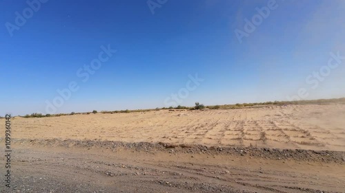 Driving on asphalt road passing through mini tornado in gobi desert on sunny autumn day in Kuqa, southern Xinjiang, China, POV from the car, 4k real time footage, travel concept. photo