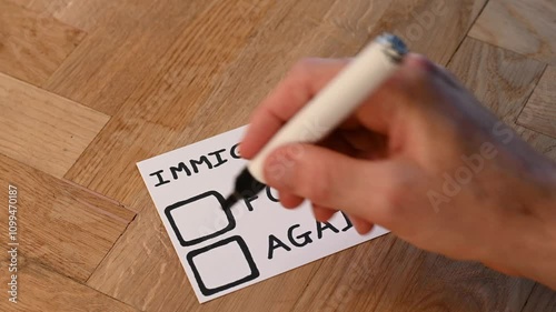 human hand with marker casts negative against vote on popular trending topic immigration. public opinion varies around outsiders, help, aid and shelter offered foreign nationals with refugee status