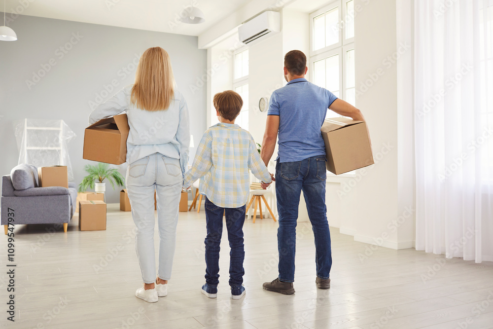 Fototapeta premium Family, owners moving new flat, enter, leave home residence rear view, parents, child, tenants holding boxes entering big modern house with belongings on moving day, positive mortgage and relocation