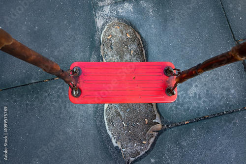 Damaged surface of rubber covering on children's playground under swings, top view photo