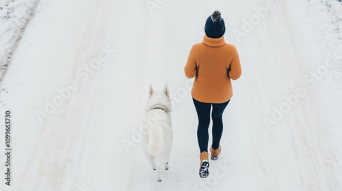 Happy woman jogging with her dog on winter street