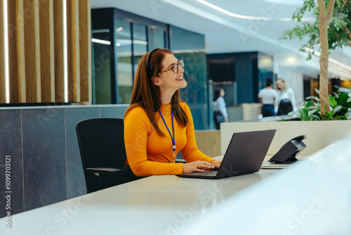 Smiling receptionist welcoming visitors at a modern company lobby