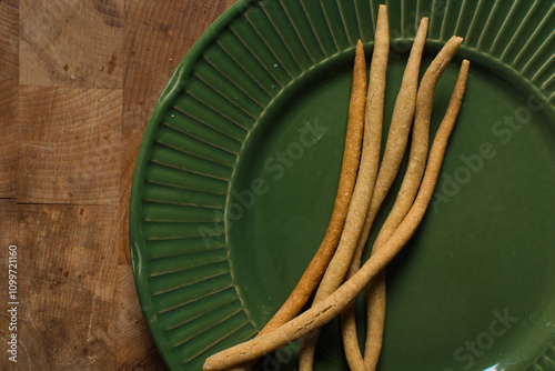 Top view of fried corn stick snack on a green plate, Overhead view of nigerian kokoro corn snack photo