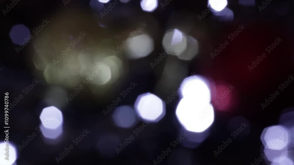 Una toma de cerca de varias luces de colores en forma de círculos en movimiento en la oscuridad. Desenfoque, efecto Bokeh