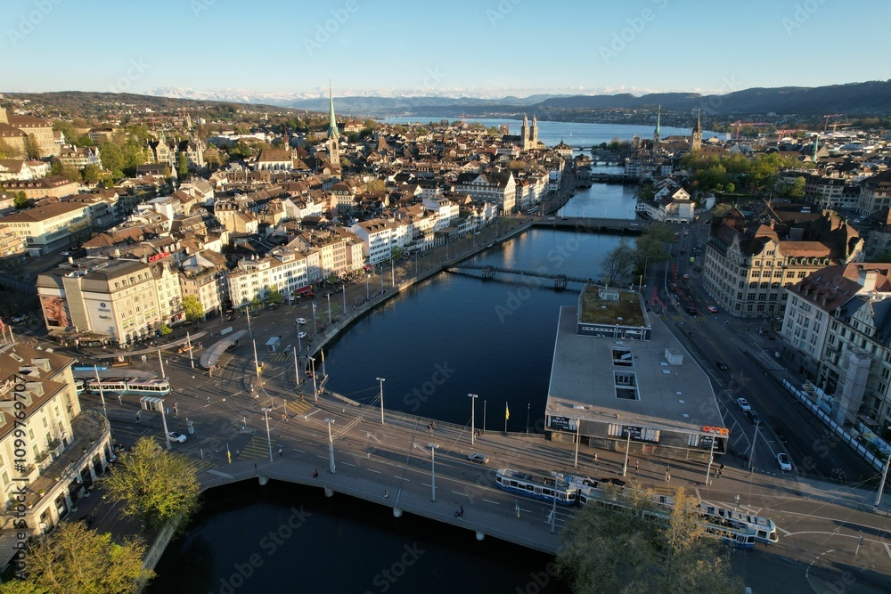 Fototapeta premium Aerial view of Zurich with historic architecture and mountain backdrop.