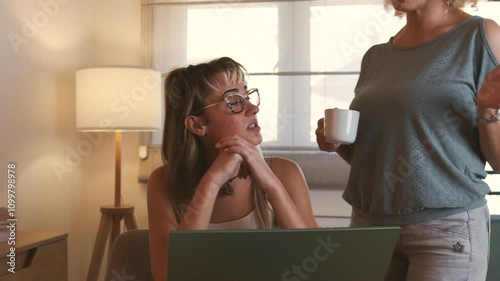 A young student sits at a table in the living room, focused on studying for an upcoming exam, while her mother stands nearby, engaged in a heated argument, expressing concern and frustration.