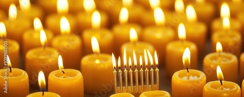 A warm display of glowing candles, with a central menorah lit among a sea of yellow candles, symbolizing celebration and light. photo