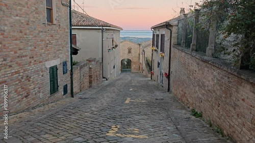 Walking in the old street of Mombaroccio medieval town at sunset in the Marche region  photo