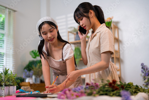 A florist taking an order over the phone while arranging flowers in a bright and well-organized shop, showcasing multitasking and professionalism
