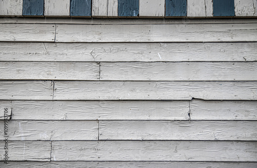 Weathered, peeling and blistered wooden siding painted white, daytime, nobody