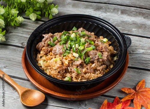 Shacha Beef Fried Rice with green onion and spoon served in bowl isolated on wooden table side view of taiwan food photo