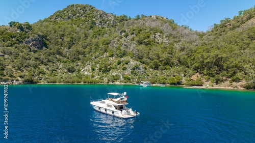 Wallpaper Mural A breathtaking drone view of a luxury yacht cruising through calm turquoise waters, showcasing its sleek design and the surrounding scenic beauty. Torontodigital.ca