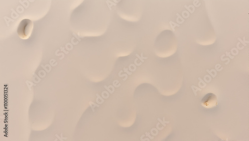 Top view of a sandy beach, texture of clean sand of a natural surface. Sand background. Imprints of mollusks in the sand. photo