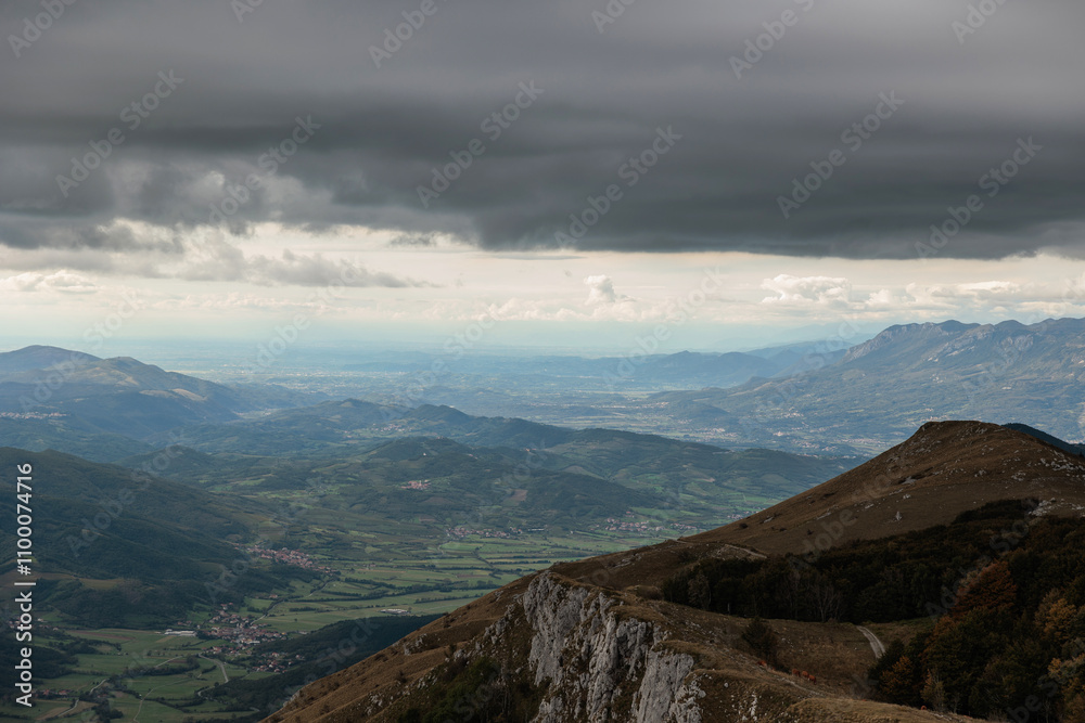 Fototapeta premium vista dettagliata dall'alto di una vasta zona ricca di catene montuose e collinari nella Slovenia occidentale, di pomeriggio, in autunno, sotto un cielo nuvoloso