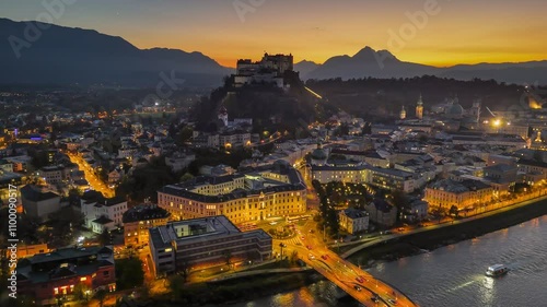 Beautiful sunset over Salzburg showcasing historic architecture and fortress. Fly over illuminated old town of Salzburg, Austria