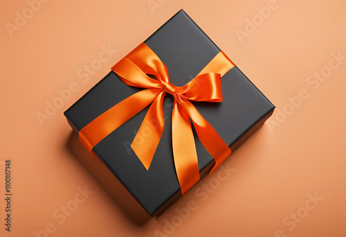 orange ribbon tied on a black gift box photo