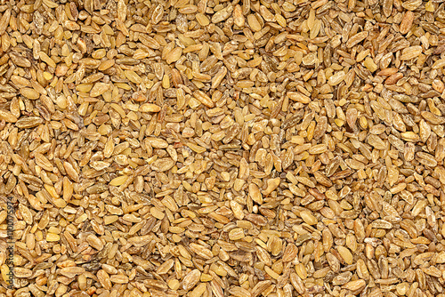 Macro photography of raw freekeh, frikeh, fire roasted green durum wheat, rubbed, cereal grain; groat; vegan food, healthy nutrition, uncooked