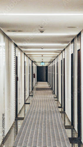 Tablou pe pânză Brightly lit hallway in a modern hotel with reflective floor and minimal design