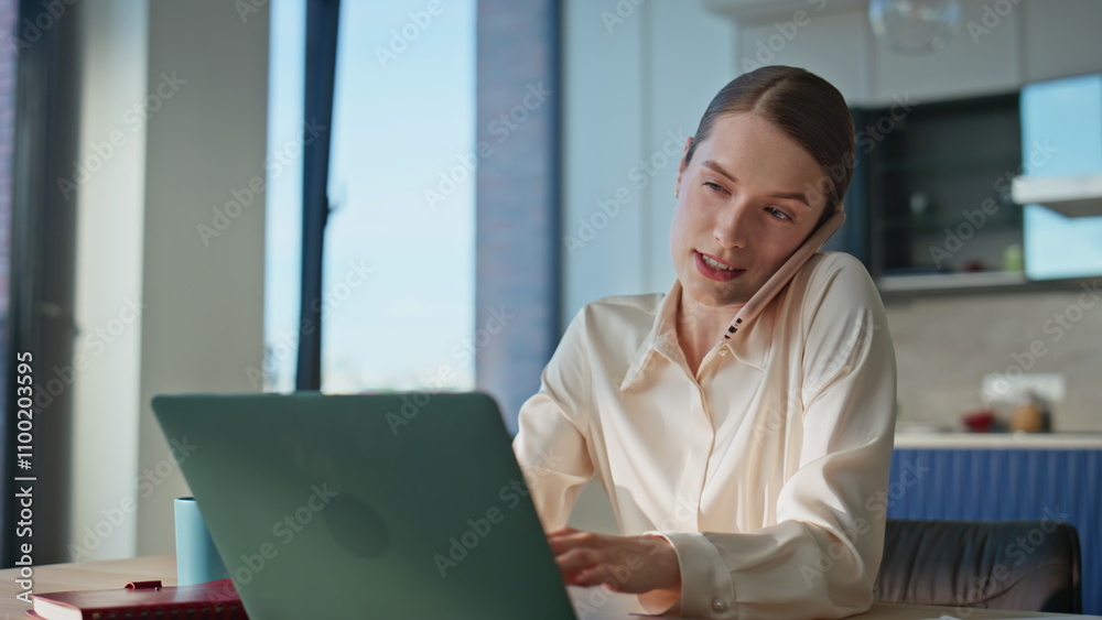 Professional woman speaking cellphone typing on laptop at home office closeup. Professional woman speaking cellphone typing on laptop at home office closeup.
