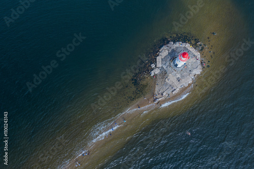 Aerial view of Tokaravskogo lighthouse on a rocky shore with tranquil waves and serene ocean, Vladivostok, Russia. photo