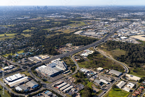 Aerial view of urban sprawl with residential and industrial buildings amidst green spaces, Oxley, Queensland, Australia.