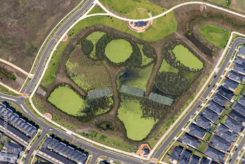 Aerial view of beautiful creekside park with ponds and residential area, Clyde, Australia. photo