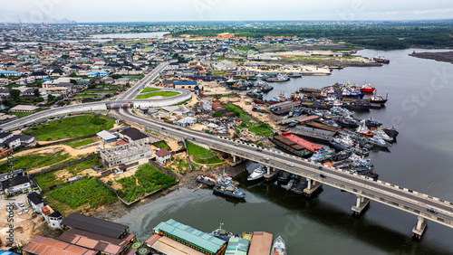 Aerial view of alcon bridge over the river with boats and buildings in a scenic urban landscape, Golf Estate, Port Harcourt, Nigeria. photo