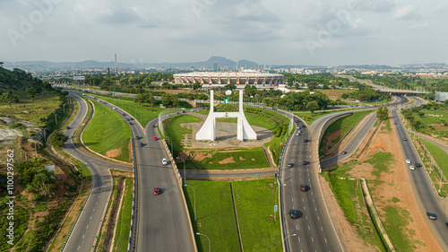 Aerial view of a bustling city intersection with modern buildings and greenery, Kukwaba District, Abuja, Nigeria.