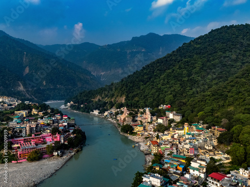 Aerial view of the serene Ganga River surrounded by vibrant mountains and the Laxman Bridge in the picturesque town of Rishikesh, Uttarakhand, India. photo