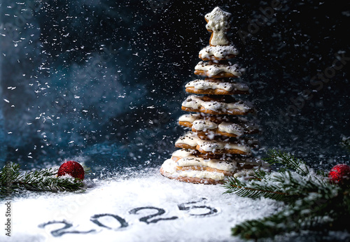 Gingerbread Christmas tree on a festive table. 2025. Sweet snow. Icing sugar. Copy space. Close-up