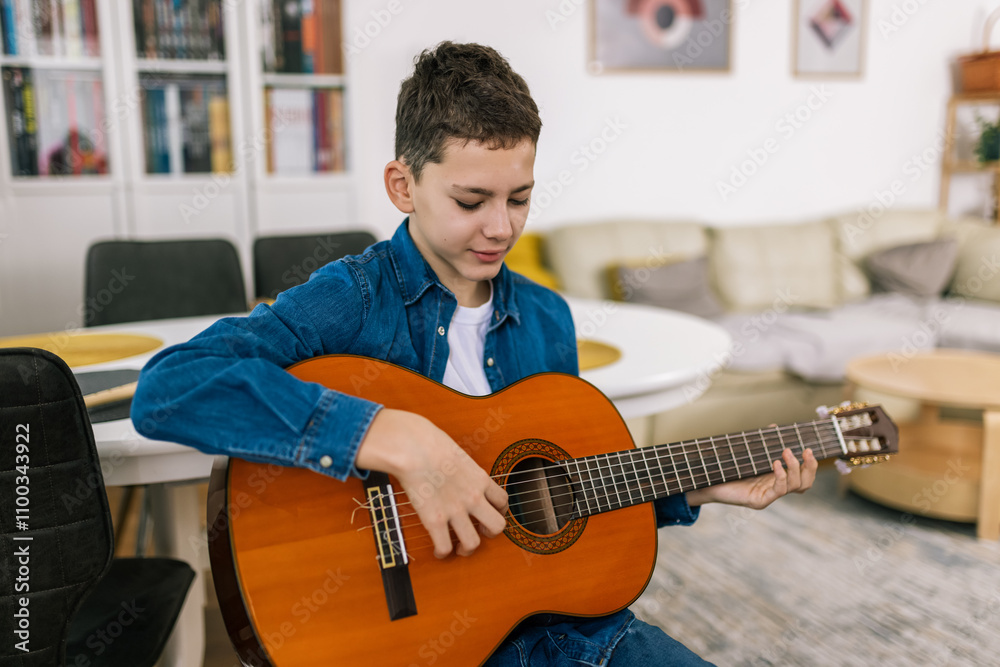 Obraz premium Boy plays guitar at home.