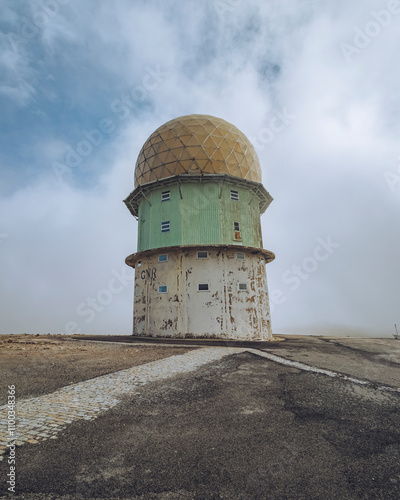 View of radar tower with geometric shapes under a cloudy sky, Torre, Serra da Estrela, Portugal. photo