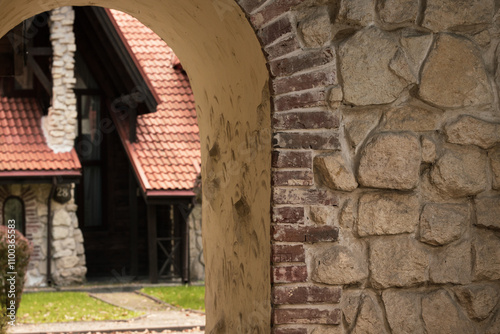 old Europe back street beautiful arch passage stone wall background roof tile ancient cottage with chimneys urban city scape aesthetic like from fantasy movies photo