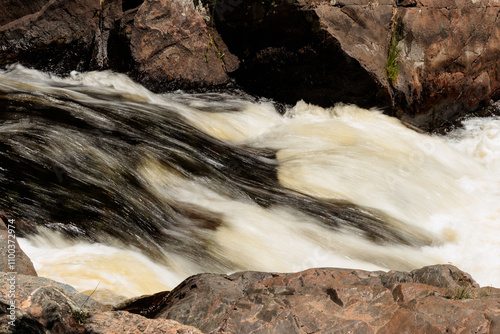 The Pike River rushes frast through a small chute on Three Foot Falls, within Twelve Foot Falls County Park near Dunbar, Wisconsin in early June photo