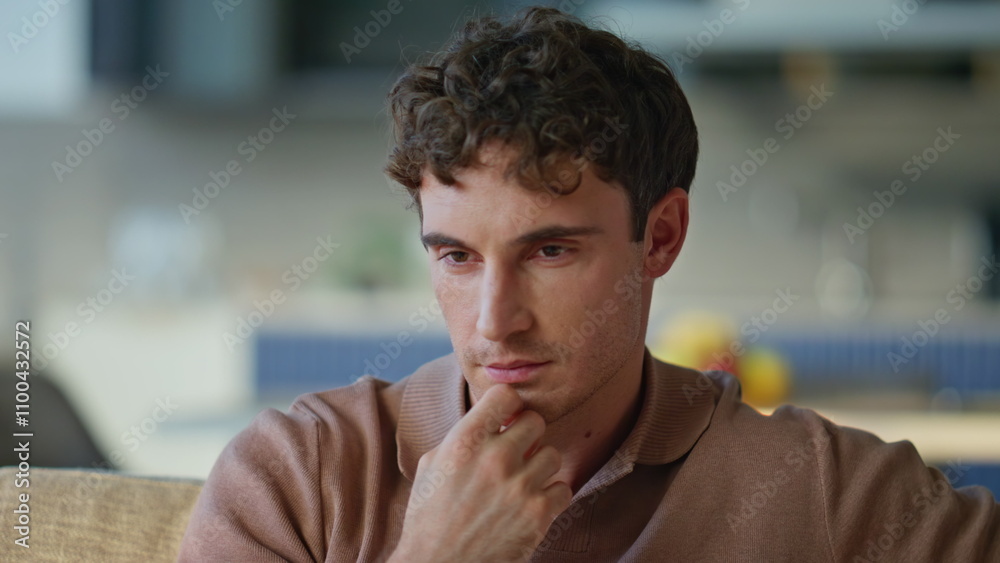 Obraz premium Thoughtful guy drinking coffee sitting sofa at relaxed home environment closeup.