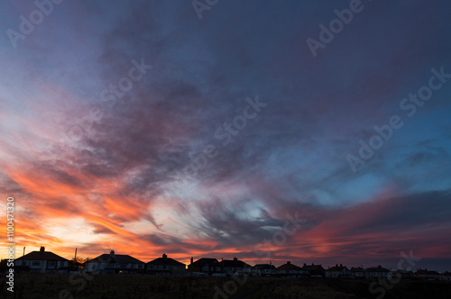Dramatic sunset over houses with copy space