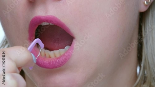 Close up of woman brushing teeth with thread, healthy lifestyle