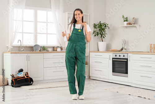 Female plumber with hoses i...