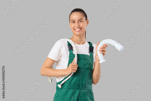 Female plumber with pipe an...