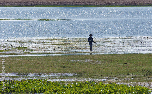 Man fishing on the banks of the Tonle Sap River, Cambodia photo