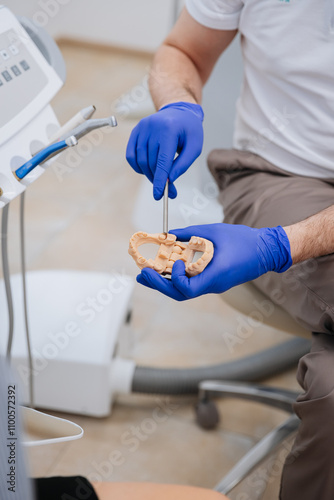 Dentist demonstrating dental model procedure with precision tools in a modern clinic setting photo