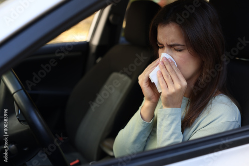 Young woman with runny nose in car