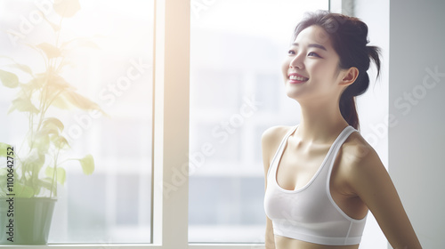 Young Asian woman enjoying a morning stretch in a bright, sunlit room, embodying wellness and tranquillity Free Download Young Asian woman enjoying a morning stretch in a bright, sunlit room, embodying wellness and tranquillity - GFXLoad